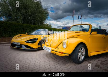 Jaune McLaren 765LT et VW Beetle Cabriolet sous ciel nuageux Banque D'Images