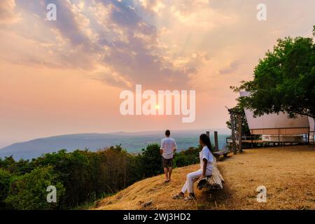 Hommes et femmes regardant le coucher du soleil dans un camping de montagne à Phitsanulok Thaïlande Banque D'Images