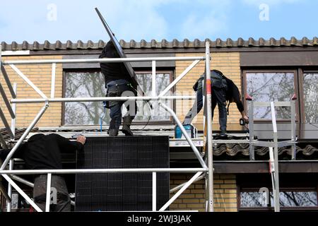 Ingénieurs de service installant des panneaux solaires sur le toit d'une maison résidentielle Banque D'Images