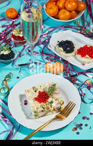 Table du nouvel an ou de Noël pour une fête à la russe avec champagne en verre, mandarines et salade Olivier en portions Banque D'Images