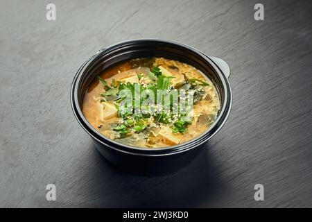 Cuisine coréenne traditionnelle, soupe au kimchi avec kimchi et tofu dans un bol en plastique Banque D'Images