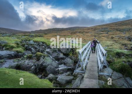 Mère et fille debout sur un pont en bois à Glendalough. Randonnée dans les belles montagnes de Wicklow d'automne, Irlande Banque D'Images