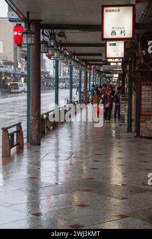 Scène avec les gens et la circulation sur la rue Shijo dans le centre-ville de Gion, Kyoto, Japon pendant la pluie. Banque D'Images