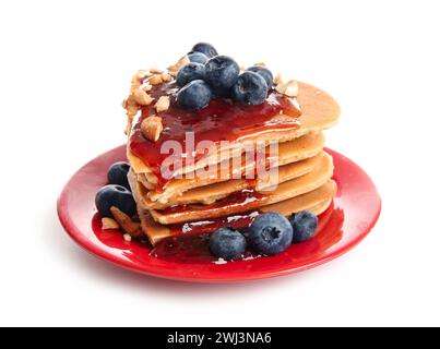 Assiette avec de savoureuses crêpes en forme de coeur, myrtille et confiture sur fond blanc. Célébration de la Saint-Valentin Banque D'Images