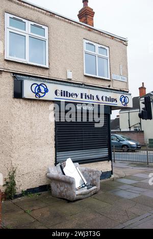 Un canapé déversé devant un magasin de fish and chips à West Marsh Estate, Grimsby, Lincolnshire. Banque D'Images