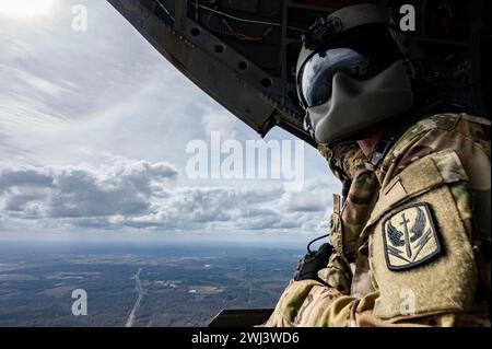 Josh Market, un ingénieur de vol affecté au 1er Bataillon de la compagnie B du 169th Aviation Regiment, est assis à l'arrière d'un hélicoptère ANG CH-47F Chinook dans le ciel au-dessus de Dannelly Field, Alabama, le 9 février 2024. Le Chinook est un hélicoptère multimission de pointe doté de capacités avancées de manutention du fret qui complètent les performances de mission et les caractéristiques de maniabilité de l’avion. (Photo de l'US Air Force par le sergent d'état-major Taylor Crul) Banque D'Images