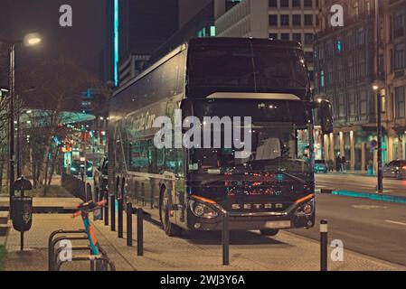 Bruxelles, Belgique. 5 02 2024. Bus par la société capitale voitures dans les rues de Bruxelles, près de la station de métro Roger. Rue de photographie nocturne abstraite Banque D'Images