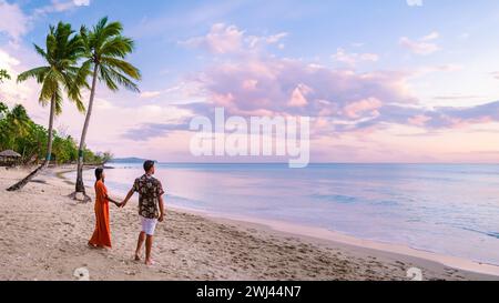 Couple sur la plage avec des palmiers au coucher du soleil sur la plage tropicale de Sainte-Lucie ou Sainte-Lucie Caraïbes Banque D'Images