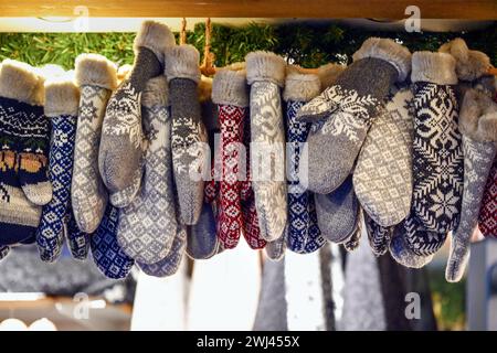 Moufles tricotées en laine, doublées de fausse fourrure, suspendues dans un kiosque de vente au marché de Noël, gants pour les mains chaudes en hiver, Banque D'Images