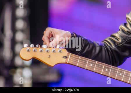 Musicien de main masculin accorde la guitare en gros plan Banque D'Images