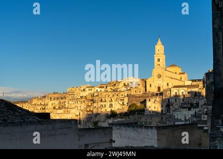 Vue sur la cathédrale historique de Maratea et les maisons en pierre des Sassi di Matera dans la lumière dorée chaude du soir Banque D'Images