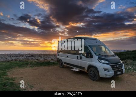 Camping-car garé sur les rives du golfe de Tarente dans les Pouilles au coucher du soleil Banque D'Images