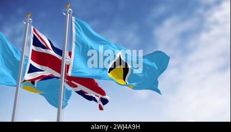 Drapeaux nationaux de Sainte-Lucie agitant avec le drapeau du Royaume-Uni par temps clair Banque D'Images