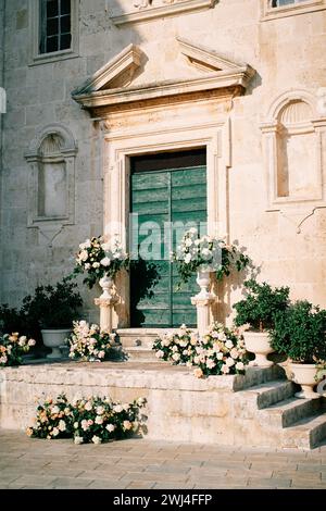 Mariage semi-arche avec bouquets de fleurs se dresse sur les marches de St. Mark Church. Perast, Monténégro Banque D'Images