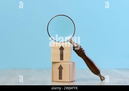 Cubes en bois et loupe sur fond bleu Banque D'Images