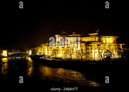 Punakha Dzong avec pont en porte-à-faux traditionnel mis en évidence la nuit. Banque D'Images