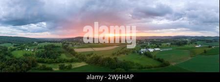 Une belle vue aérienne panoramique sur les nuages et le coucher de soleil sur les belles terres agricoles verdoyantes du comté de Lancaster, en Pennsylvanie. Banque D'Images