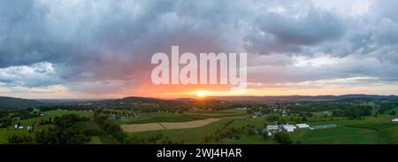 Une belle vue aérienne panoramique sur les nuages et le coucher de soleil sur les belles terres agricoles verdoyantes du comté de Lancaster, en Pennsylvanie. Banque D'Images