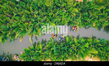 Vue aérienne, les touristes sont détendus et l'expérience d'une excursion en bateau de panier à l'eau de coco (palmier de mangrove) forêt dans le village de Cam Thanh, Hoi an, Quang Na Banque D'Images