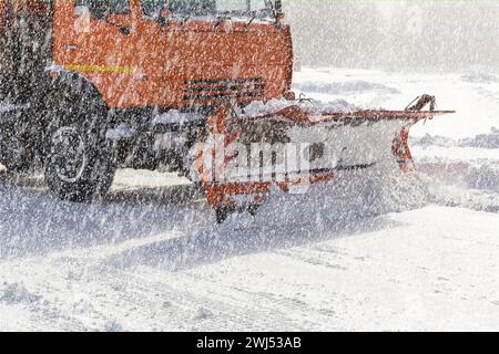 Chasse-neige déneigeant une route urbaine Banque D'Images