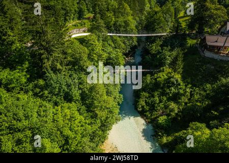 Pont suspendu sur la rivière alpine dans la forêt verte, Slovénie. Vue aérienne du drone Banque D'Images