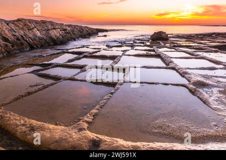 Salines à la plage de Marsaskala, Malte au lever du soleil Banque D'Images