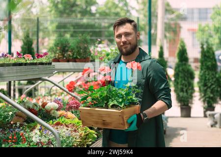 Fleuriste travaillant et organisant des pots de fleurs dans le magasin de jardin Banque D'Images