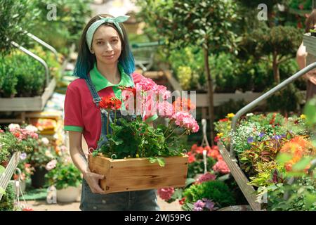 Fleuriste travaillant et organisant des pots de fleurs dans le magasin de jardin Banque D'Images