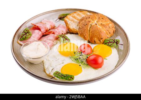 Assiette de petit déjeuner avec oeufs au plat, bacon et toasts isolés sur blanc Banque D'Images