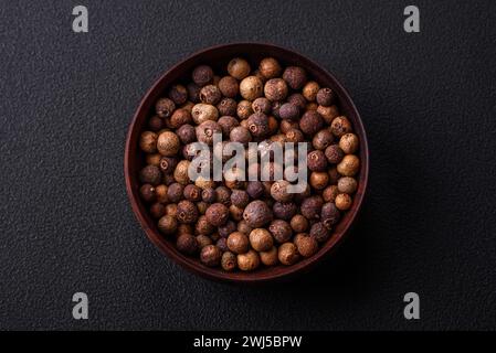 Épice Allspice couleur brune pas moulue dans une soucoupe en bois. Cuisine asiatique Banque D'Images