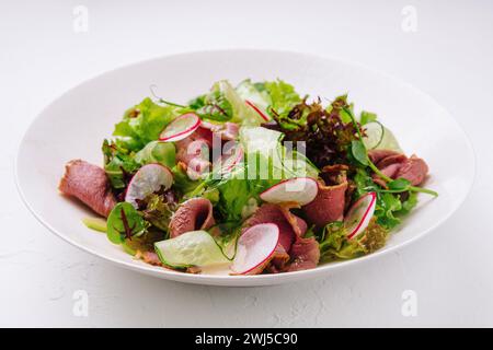 Salade de rôti de bœuf avec mélange vert sur assiette Banque D'Images