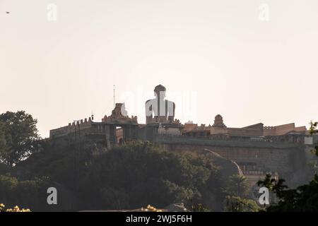 La statue imposante de Gommateshwara se dresse sereinement au sommet de la colline de Vindhyagiri à Shravanabelagola, capturée ici contre la douce lueur du soleil couchant Banque D'Images