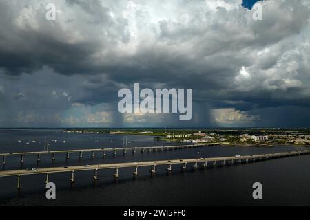 Nuages orageux se formant à partir de l'humidité évaporante de l'eau de l'océan avant l'orage sur le pont de circulation reliant Punta Gorda et Port Charlotte plus Banque D'Images