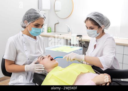 Chirurgien dentiste professionnel et assistant effectuant l'opération dentaire dans une clinique avec l'équipement moderne Banque D'Images