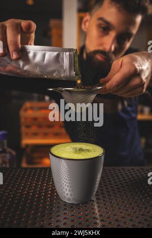 Latte au thé vert matcha décoré de barman avec de la poudre de matcha Banque D'Images
