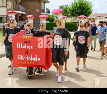 Filles vêtues de costumes comme des bouteilles de Mahou lager espagnol dans les fêtes de procession d'été août 2023 Lantadilla Palencia Castille et Léon Espagne Banque D'Images