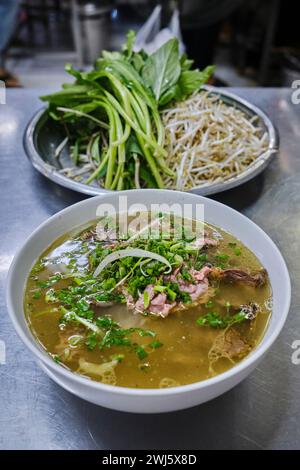 Un bol de pho de bœuf (phở) servi avec des condiments de légumes Banque D'Images