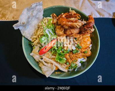 Un bol de nouilles Quang vietnamiennes (mi quang / mì Quảng), un plat de nouilles vietnamiennes originaire de la province de Quang Nam dans le centre du Vietnam Banque D'Images