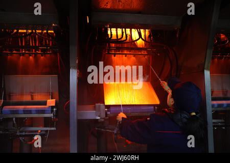 CHONGQING, CHINE - 11 FÉVRIER 2024 - Un travailleur effectue une opération de tréfilage dans l'atelier de production d'une entreprise de fibres de verre à Chongqing, CH Banque D'Images