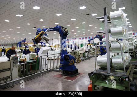 CHONGQING, CHINE - 11 FÉVRIER 2024 - Un robot transfère des produits en fibre de verre dans l'atelier de production d'une entreprise de fibre de verre à Chongqing, en Chine, Banque D'Images