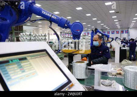 CHONGQING, CHINE - 11 FÉVRIER 2024 - Un robot transfère des produits en fibre de verre dans l'atelier de production d'une entreprise de fibre de verre à Chongqing, en Chine, Banque D'Images