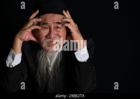 Portrait d'un vieil homme au visage ridé avec une longue barbe blanche sur fond noir, prise en studio Banque D'Images