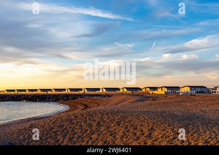 Maisons de vacances mobiles se garer à Selsey à la plage de galets au coucher du soleil, lumière de l'heure dorée Banque D'Images