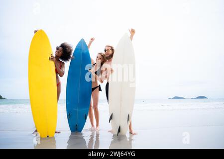 Portrait de jeune femme souriante en bikini avec planche de surf à la plage Banque D'Images