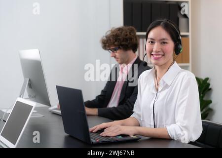 Groupe de professionnels portant un micro-casque et travaillant activement au bureau. Centre d'appels, télémarketing, agent de support client fournir Banque D'Images