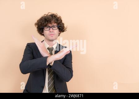 Portrait d'un beau jeune homme avec des cheveux bouclés sur un fond beige Banque D'Images