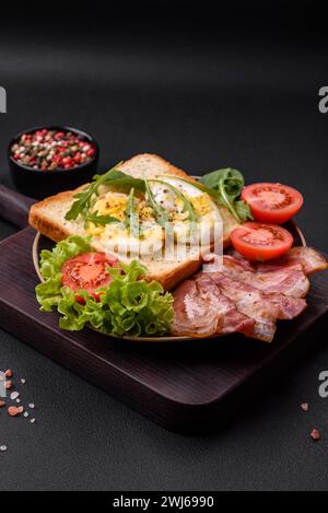 Délicieux déjeuner sain composé de bacon, pain grillé, œufs et tomates Banque D'Images