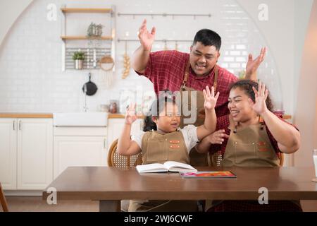 Une grande famille avec un père portant une prothèse de jambe, est heureux d'aider un enfant avec ses devoirs et de s'amuser ensemble Banque D'Images