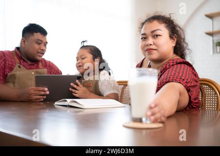 Une grande famille avec un père portant une prothèse de jambe, est heureux d'aider un enfant avec ses devoirs et de s'amuser ensemble Banque D'Images