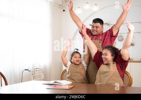 Une grande famille avec un père portant une prothèse de jambe, est heureux d'aider un enfant avec ses devoirs et de s'amuser ensemble Banque D'Images